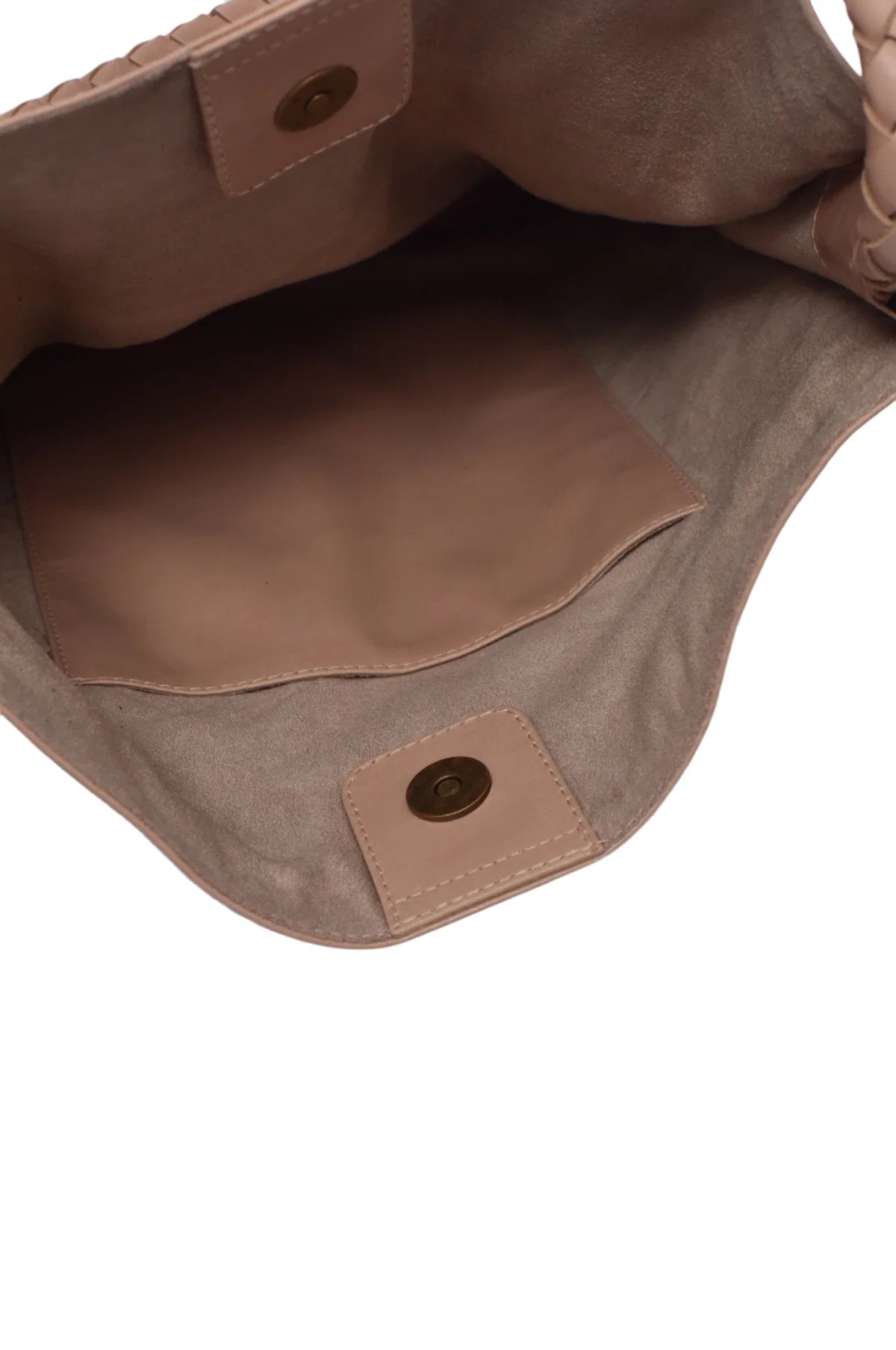 Close-up of interior of beige leather bag with visible stitching and hardware.