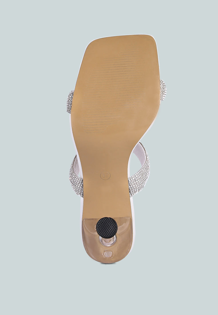 White high-heeled sandal with metallic heel, rhinestone details, and square toe on a white background, bottom view