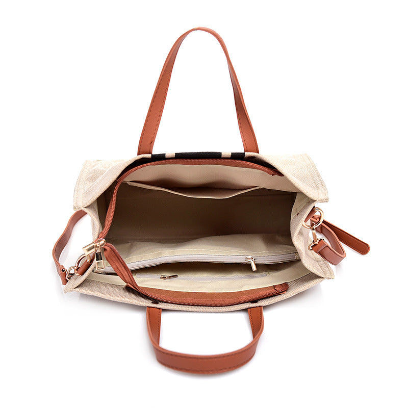 Open beige handbag with brown handles and straps on a white background