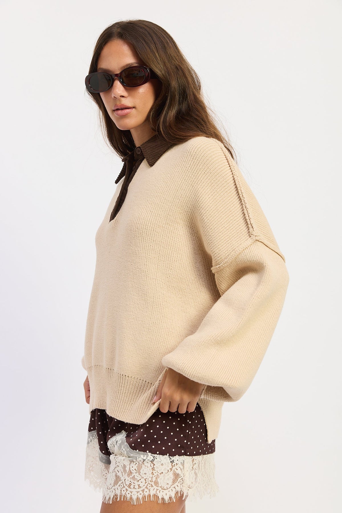 Side view of oatmeal collared knit sweater showing relaxed fit, dropped shoulders and side slit hem.