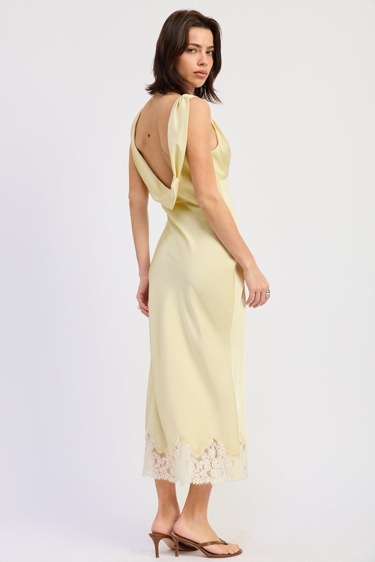 Woman wearing bias-cut satin midi dress with lace hem in Butter Yellow.