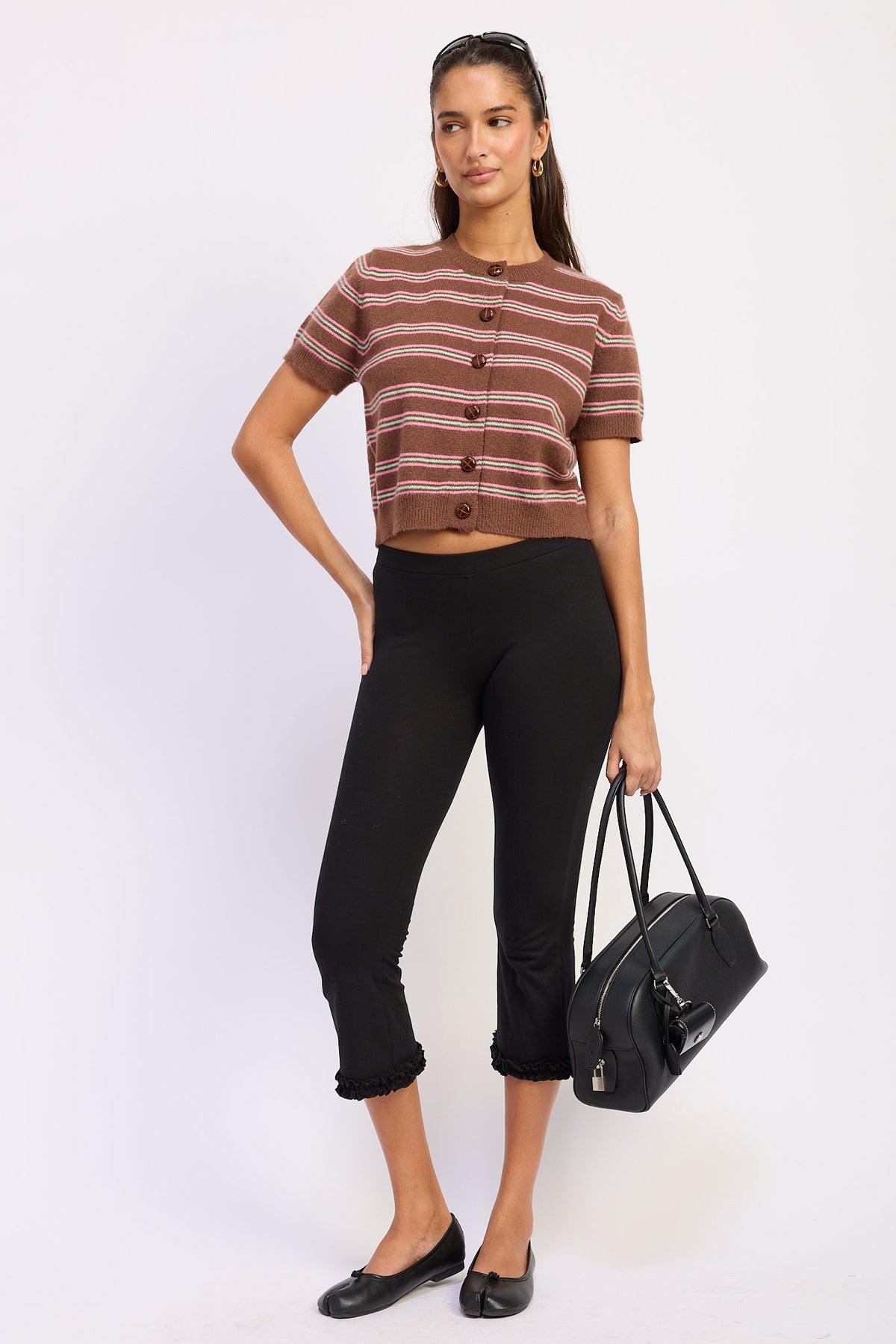 Full length view of Varsity Lines striped short sleeve cardigan in Brown Combo styled with black cropped pants and ballet flats.