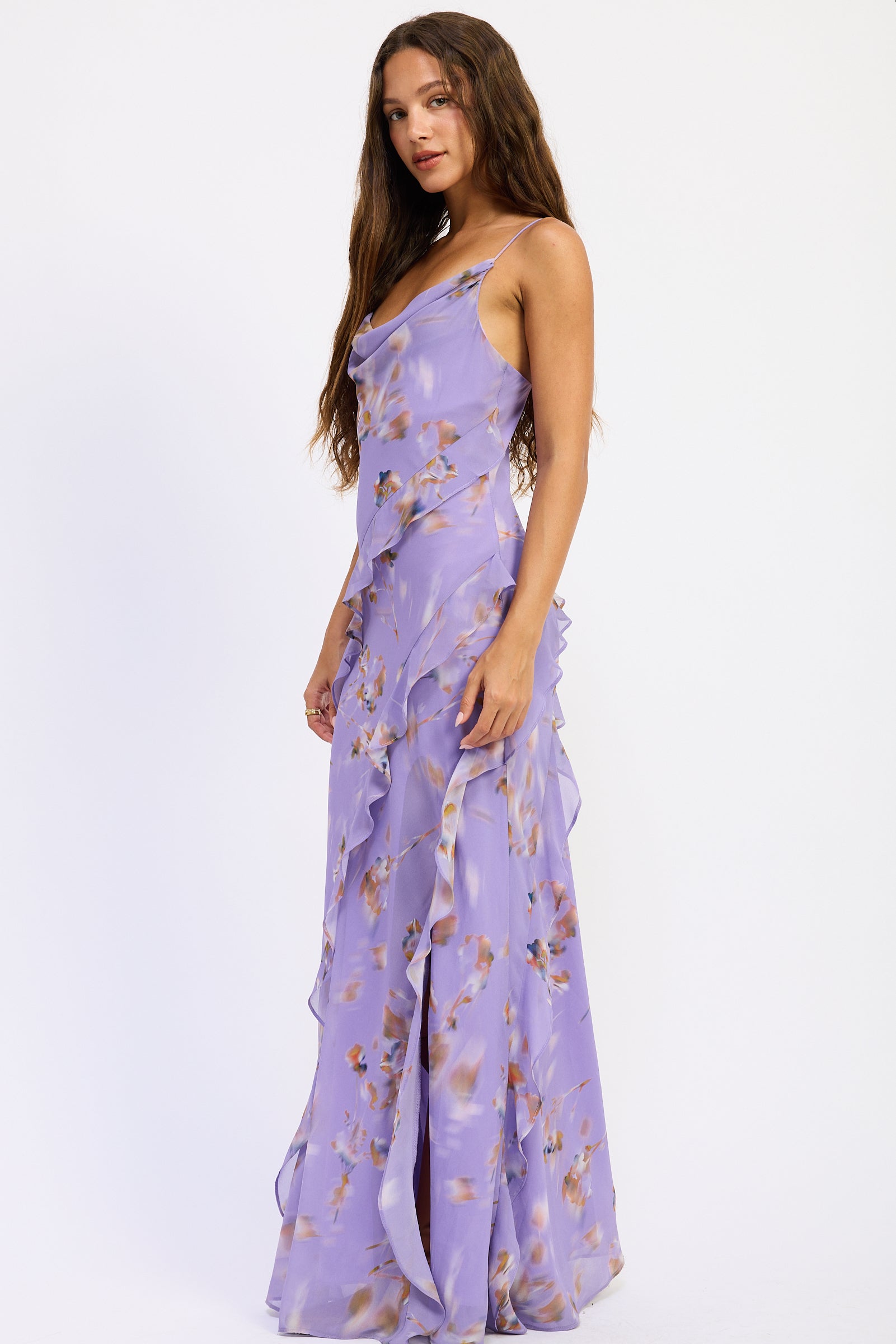 Side view of lavender floral ruffle maxi dress with cowl neckline, spaghetti straps, cascading ruffles and front slit.