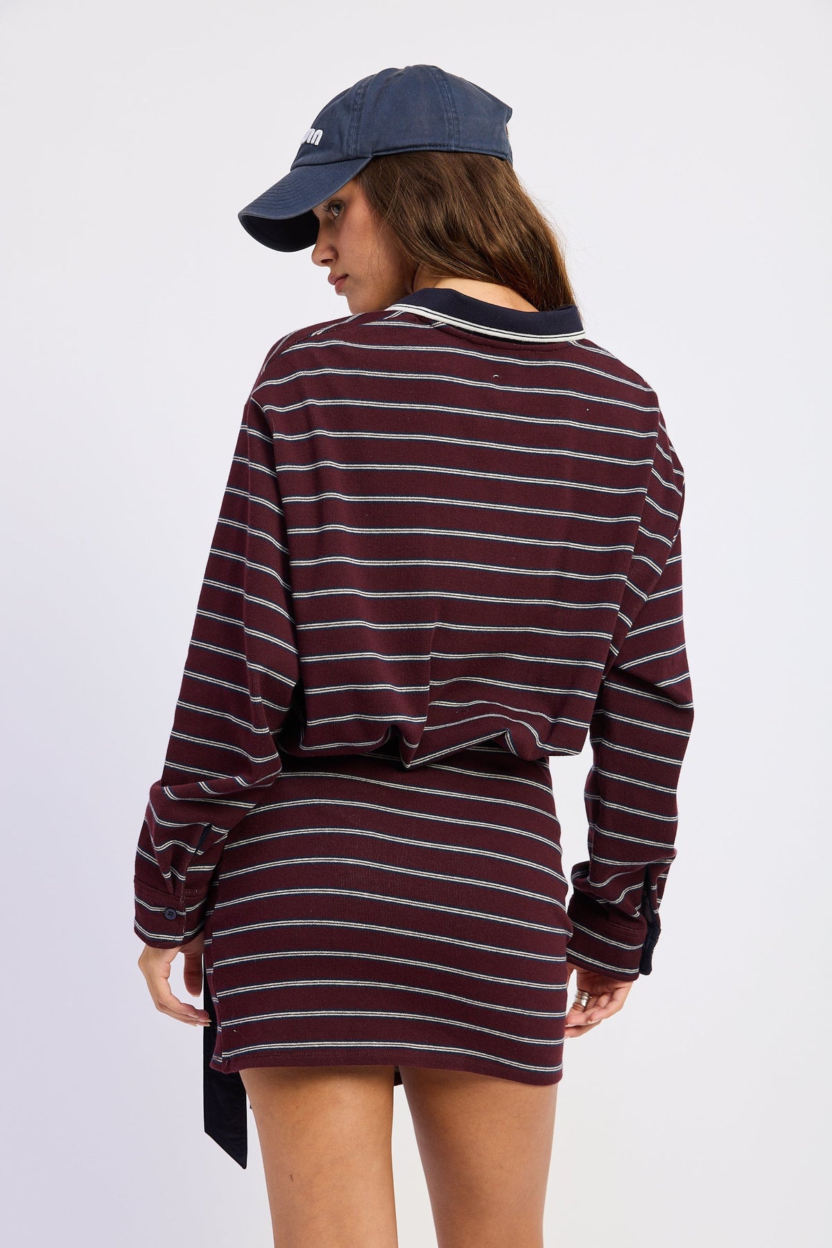 Back view of burgundy Varsity Club Striped Polo Mini Dress with horizontal stripes, navy collar and long sleeves.