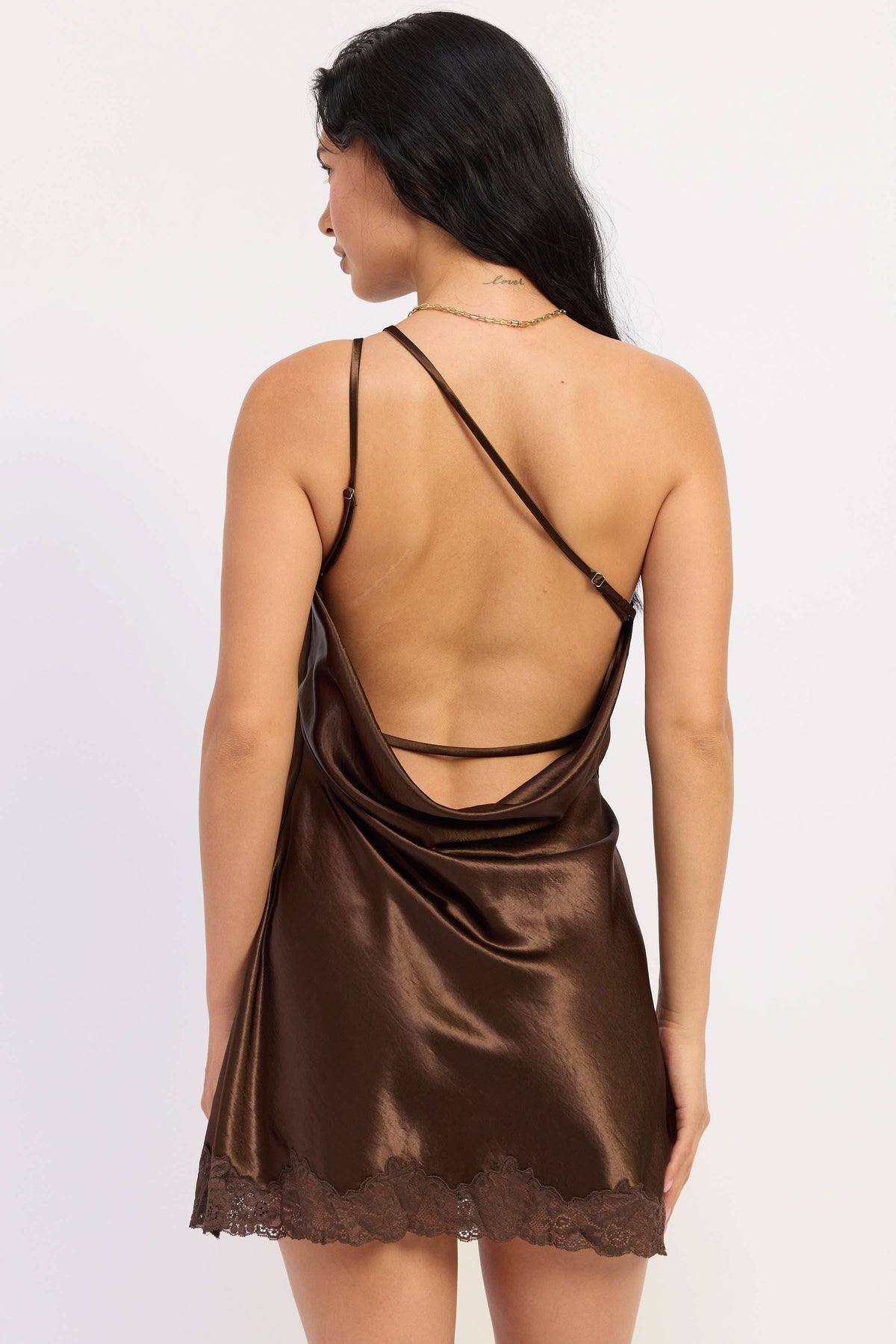 Woman wearing dark chocolate satin mini dress with lace trim.
