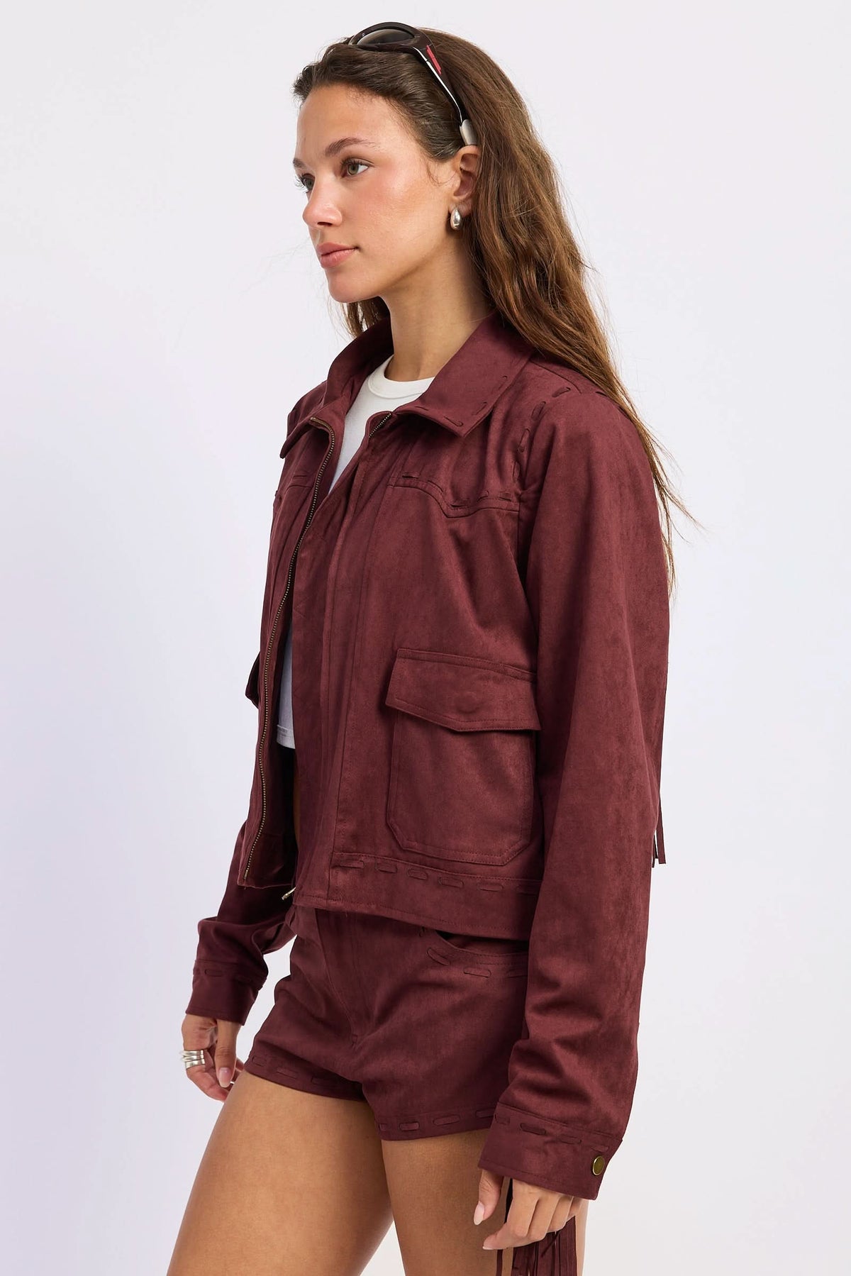Woman wearing cropped suede-look jacket with collar and long sleeves in Wine.
