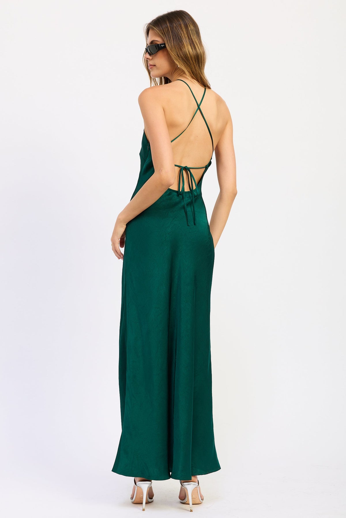 Back view of emerald green Seraphina Satin Halter Maxi Dress featuring open back, crisscross straps and adjustable tie