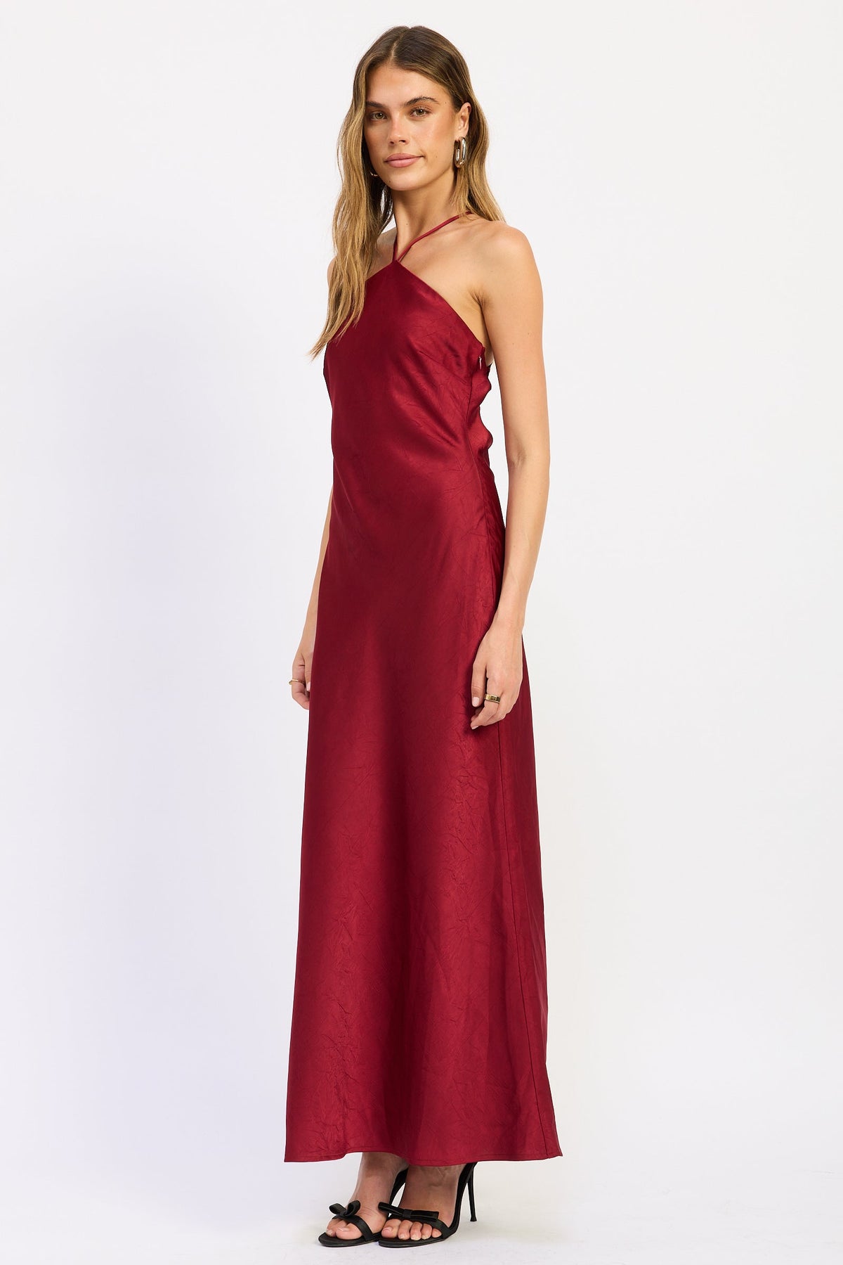 Side view of ruby red Seraphina Satin Halter Maxi Dress showing smooth satin finish and long silhouette