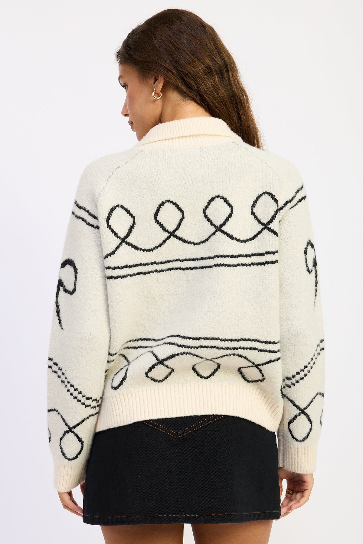 Back view of ivory and black Doxie Darling Dachshund Cardigan showing looping graphic knit pattern.
