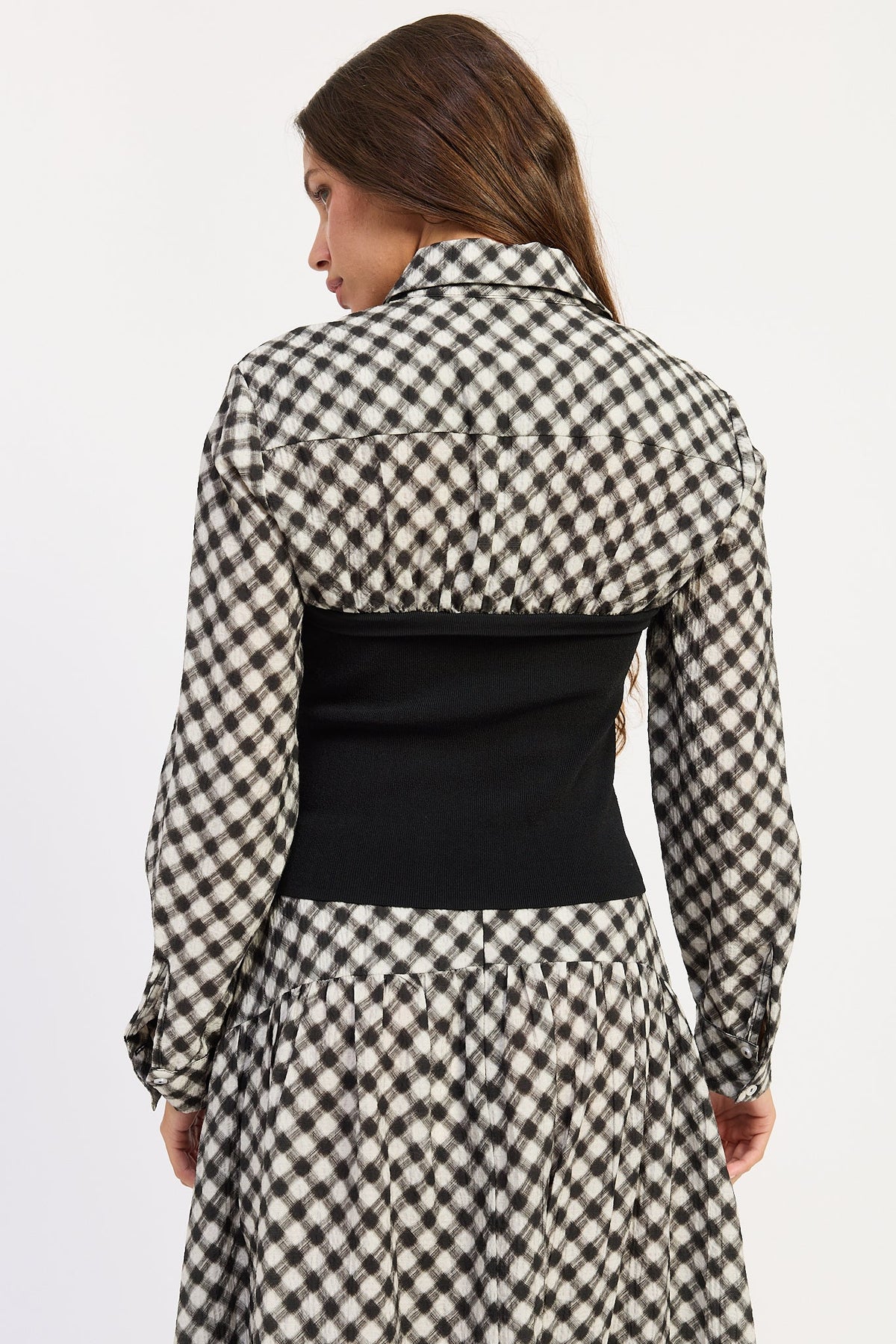 Back view of Thea black and ivory plaid top showing collared shirt detail and fitted black knit body.