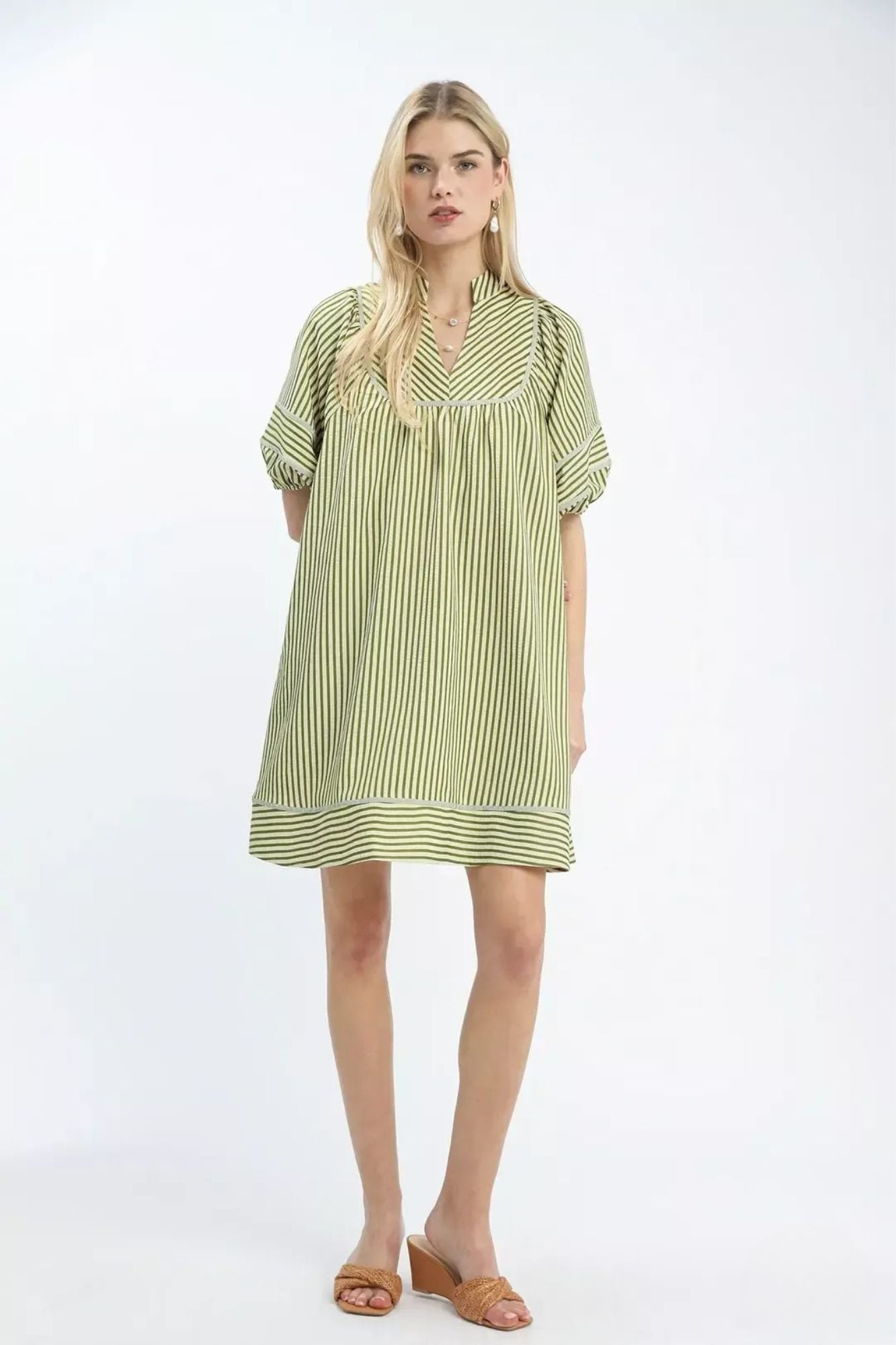 Full length front view of green stripe V neck mini dress styled with tan wedge sandals, AVAH
