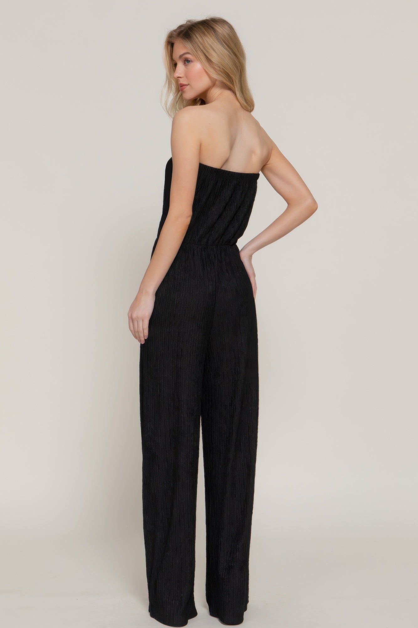 Back view of strapless black textured jumpsuit