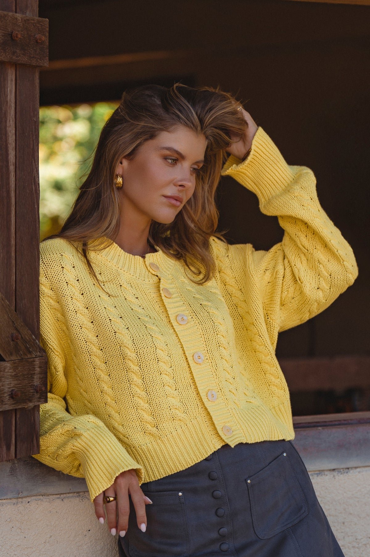 Woman wearing a yellow knitted cardigan outdoors