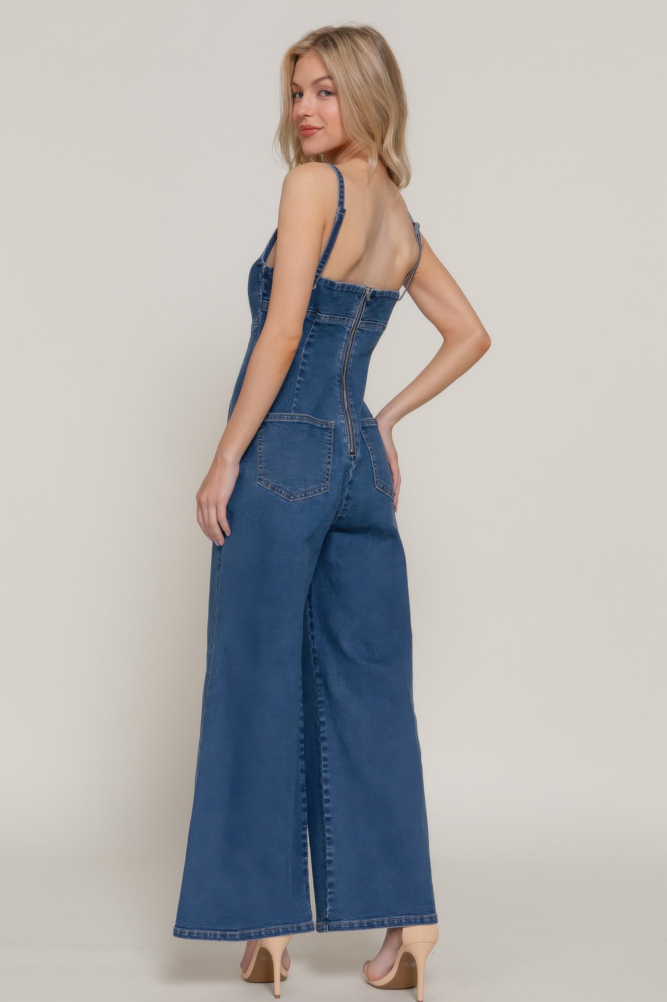 Back view of the denim-look jumpsuit showing zip closure and patch pockets