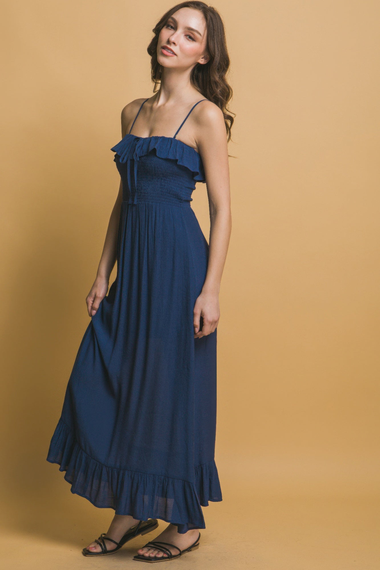 Side view of navy maxi dress showing ruffle neckline and relaxed silhouette.