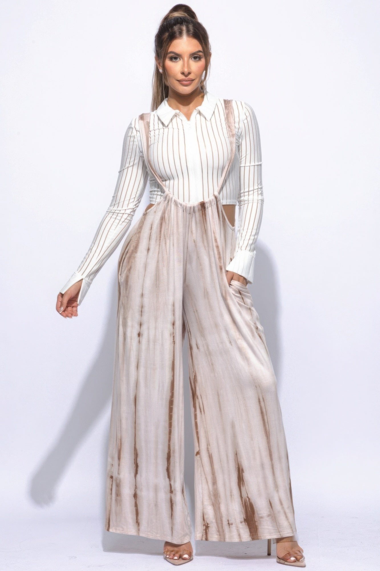Woman wearing Sahara Glow tie-dye wide-leg jumpsuit with long sleeves and collar underneath.-AVAH