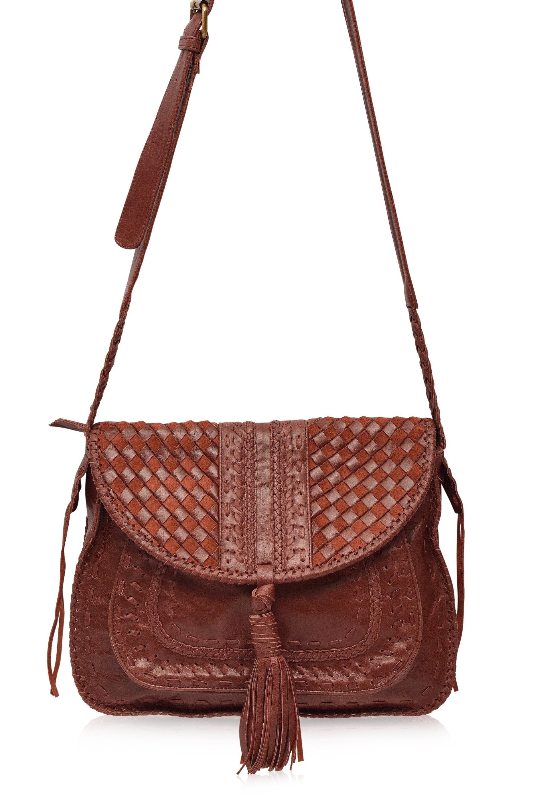 Brown worn leather woven handbag with a tassel and long adjustable strap on a white background