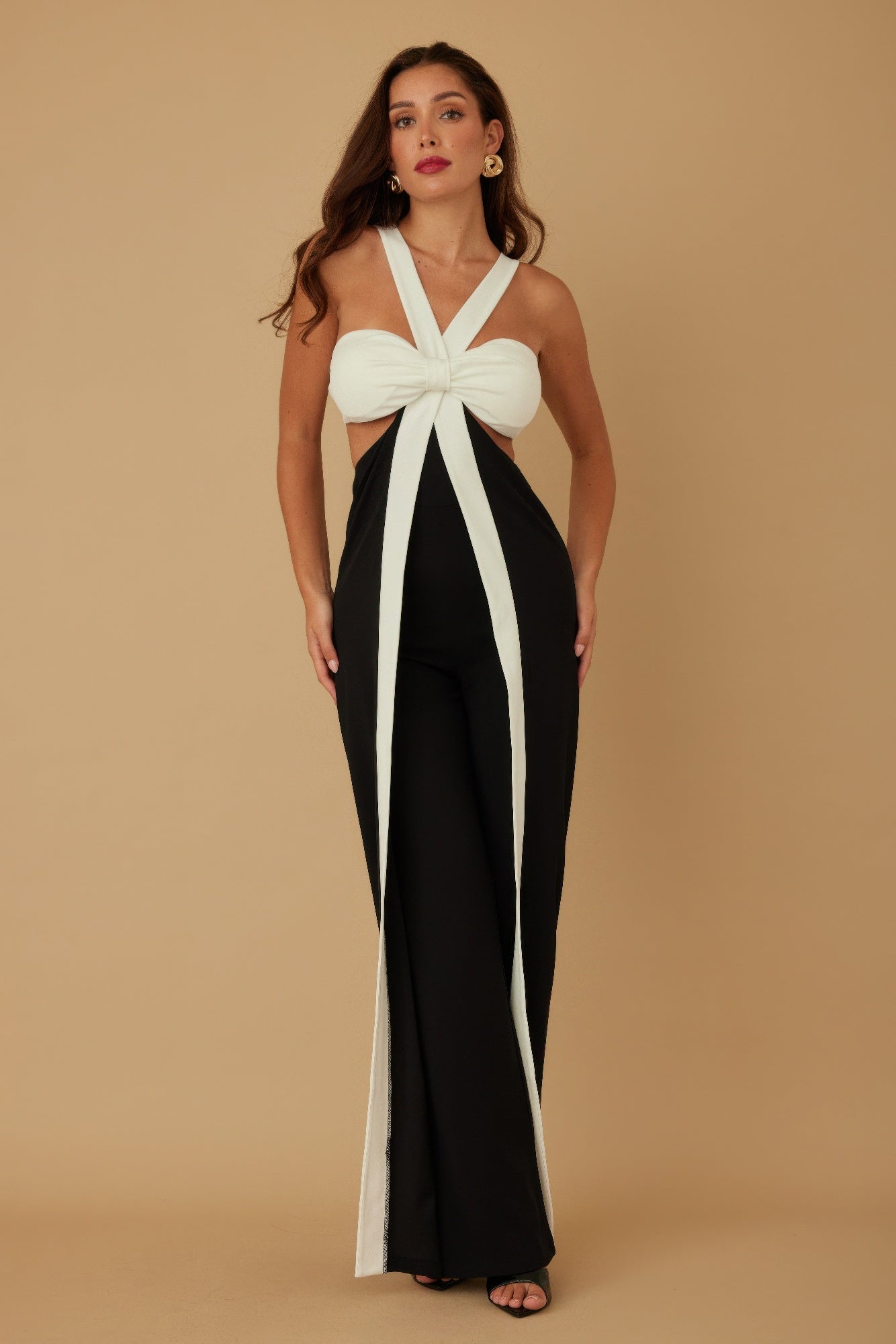 Front view of black and white halter jumpsuit with wide legs and bow top