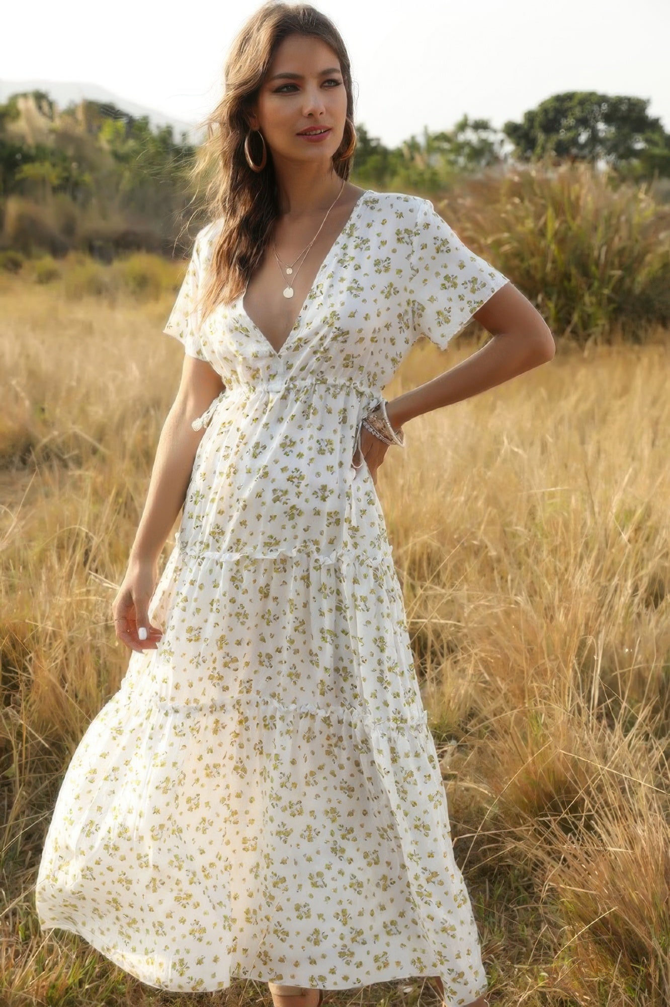 Woman in a white floral dress standing in a field