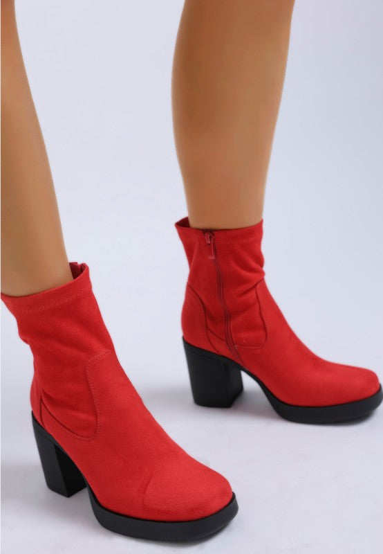 Close-up of red platform block heel boots with side zipper.