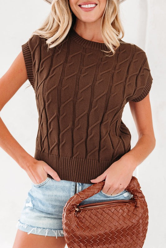 Front view of brown cable knit sleeveless top styled with light denim shorts and woven bag.