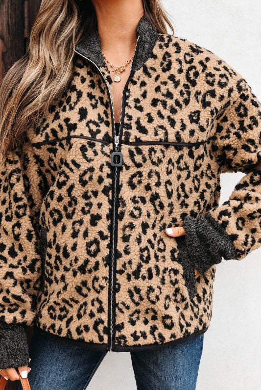 close-up of woman wearing leopard sherpa jacket zipped up with contrast cuffs