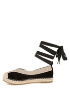 Black espadrille flat featuring beige trim and jute-style sole, side profile