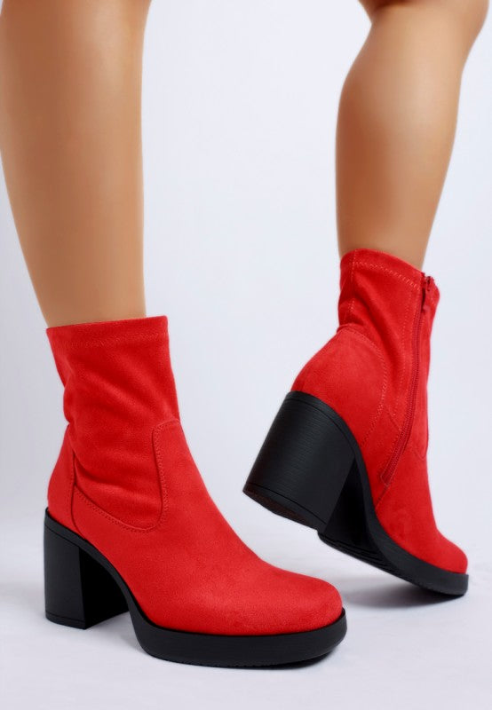 Back view showing heel height and sleek finish of red boots.