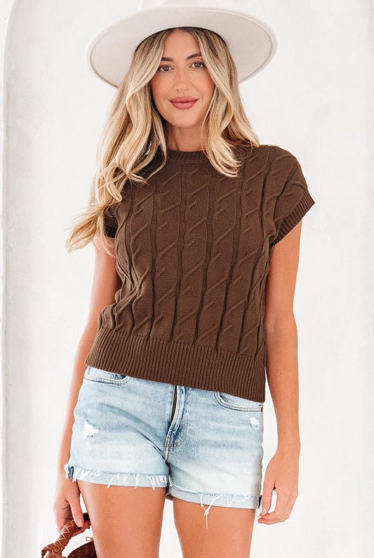 Full front view of brown sleeveless knit top on model wearing white hat and denim shorts.