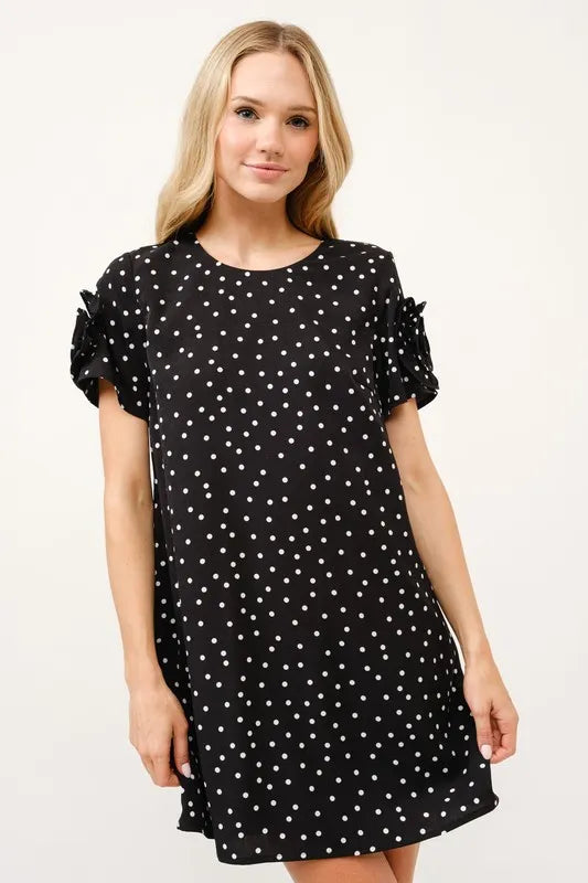 Model wearing a black polka dot shift dress with floral sleeve details and relaxed silhouette | AVAH Collections
