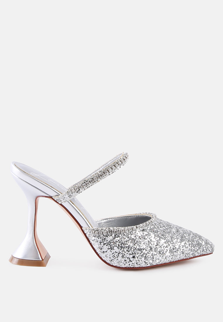 Silver glitter mules with rhinestone embellishment, sculpted heel, pointed toe and crystal decorated elastic strap Side view
