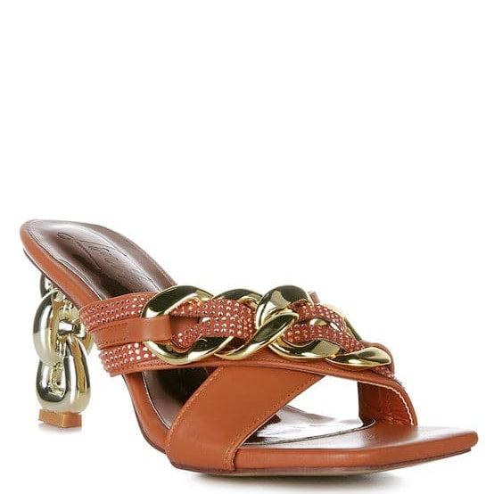 Give your look a unique touch of creativity with these stylish metallic chain-heeled sandals. The golden chain strap and head-turning diamante detail will give any outfit the right amount of edge and glamour. Chic, unique, and full of style. Avah Couture