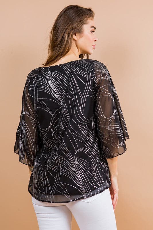 Holiday sparkle! This blouse is perfect for any occasion. All you need is a new pair of strappy sandals and your favorite trousers or jeans and you’re ready to go. Features glittered print, tulip sleeves and full lining. Avah Couture
