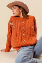 Copper Meadow Floral Knit Sweater styled with light wash jeans, showing relaxed fit and floral embroidery.