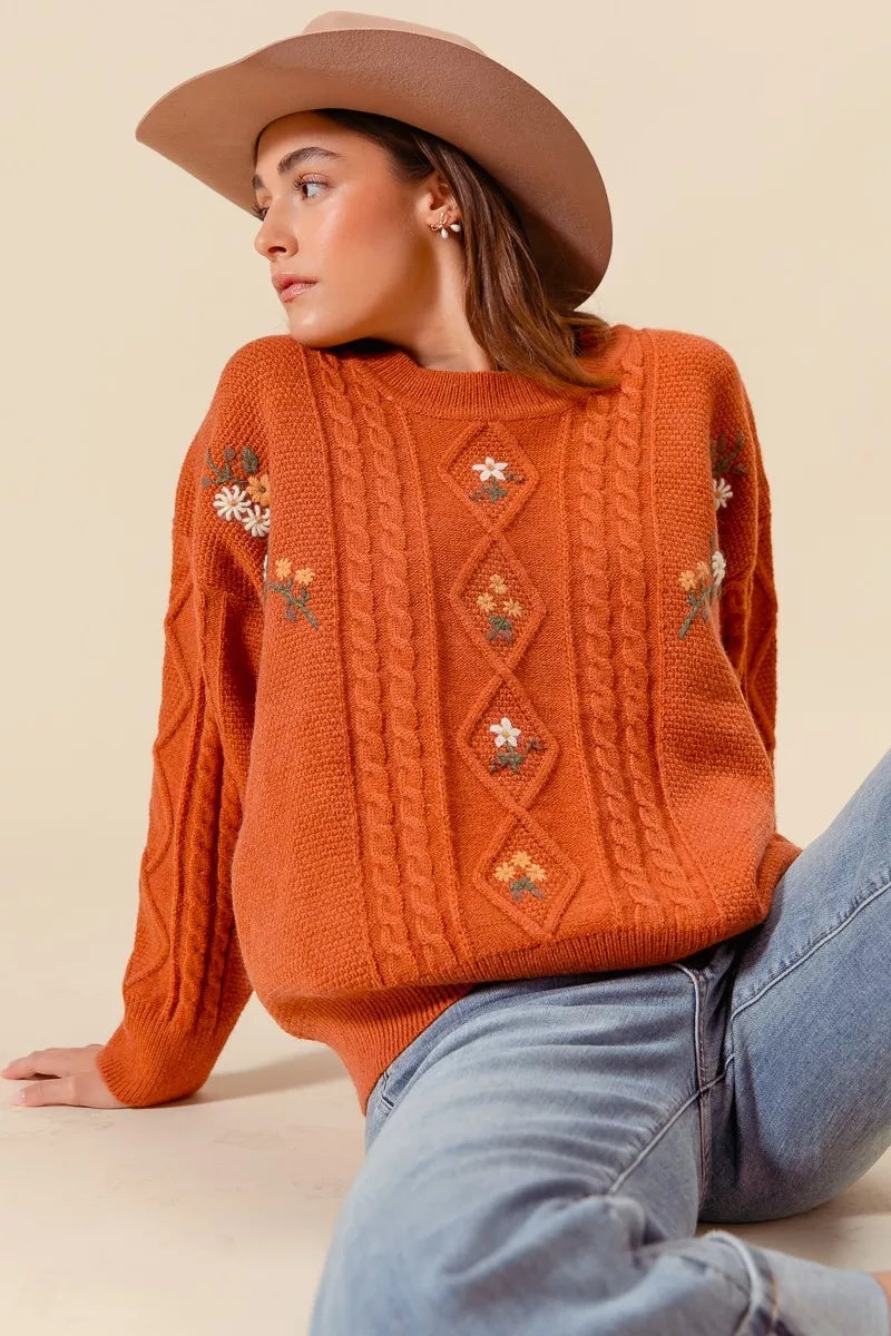 Copper Meadow Floral Knit Sweater styled with light wash jeans, showing relaxed fit and floral embroidery.