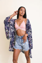 AVAH-Model wearing navy tropical kimono over pink bralette and distressed denim shorts.