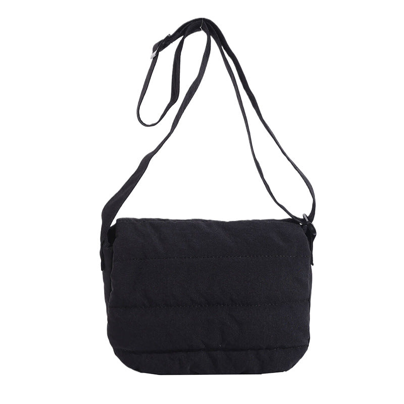 Black shoulder bag with a strap on a white background