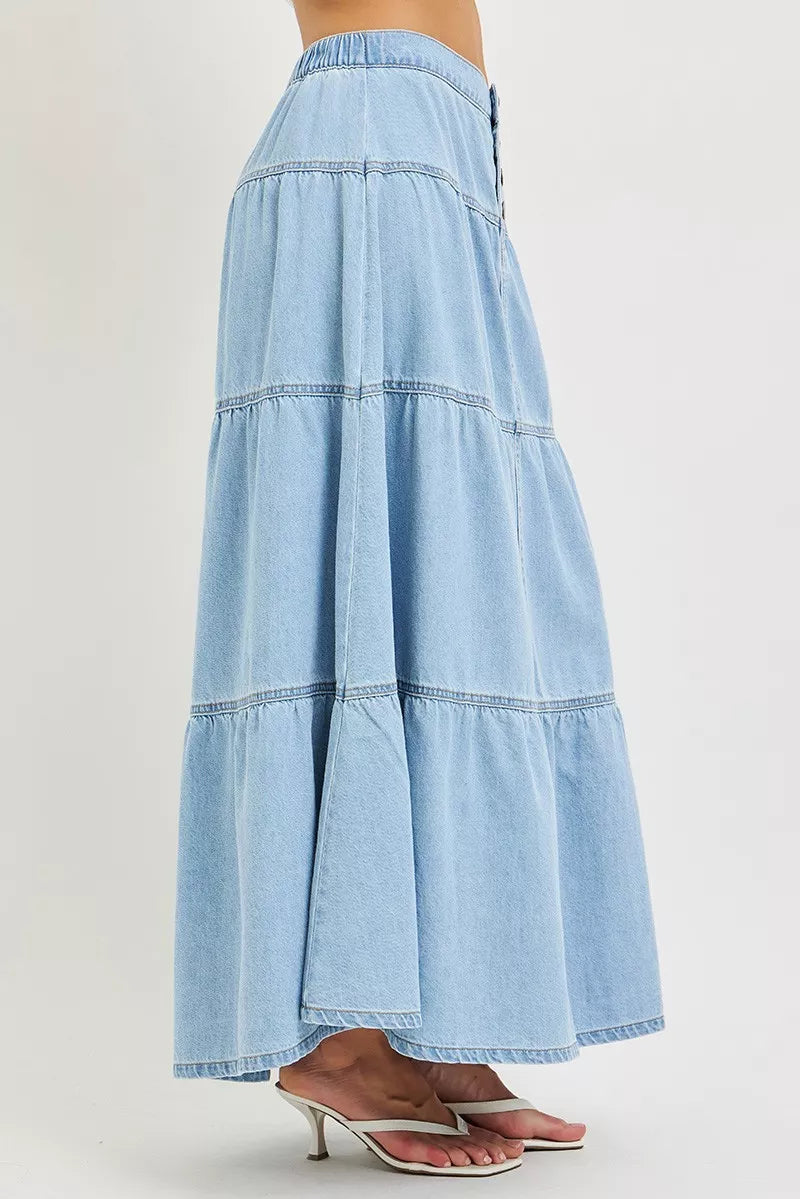 Side view of light wash cotton denim maxi skirt with flowing tiered silhouette
