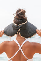 wide brim straw visor hat with leopard trim worn at the beach