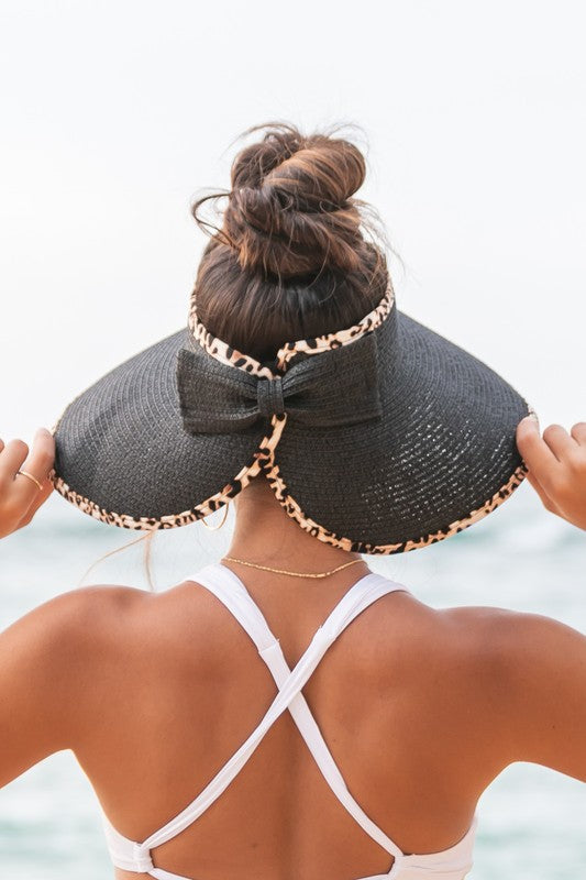 wide brim straw visor hat with leopard trim worn at the beach