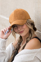 Front view of camel suede cap with curved brim
