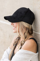 Side view of black suede cap with curved brim
