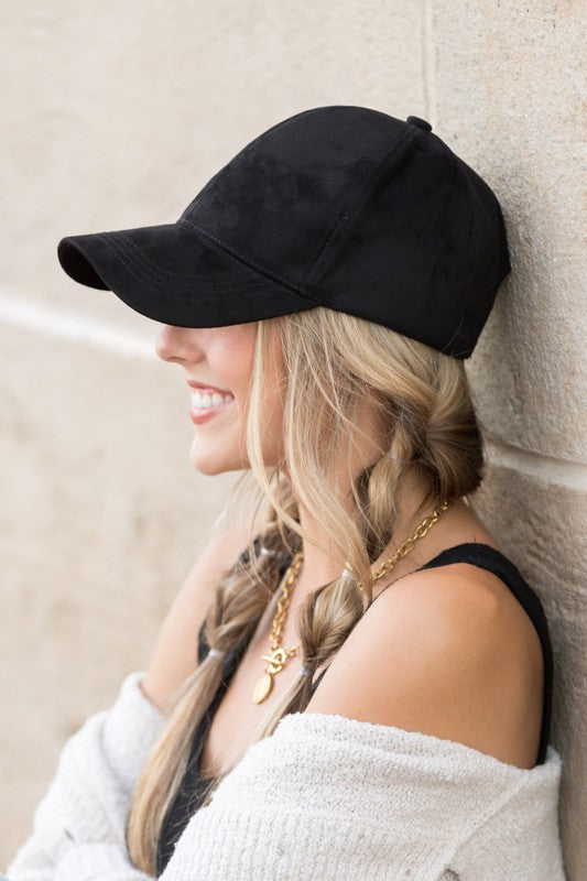 Side view of black suede cap with curved brim
