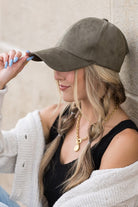 Side view of olive suede cap with soft curved brim