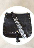 Overhead flat lay of black bag with hardware and strap shown