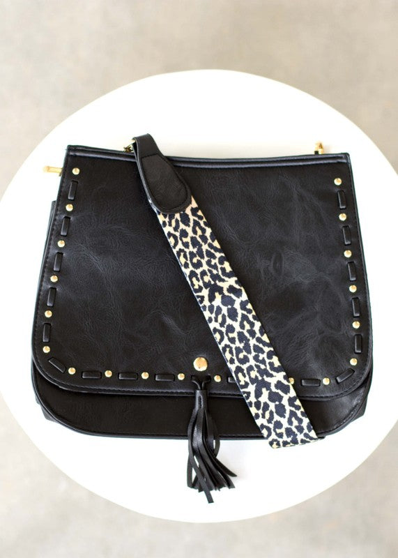Overhead flat lay of black bag with hardware and strap shown