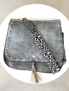 Overhead flat lay of slate gray bag with leopard print strap
