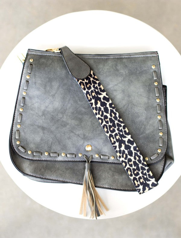 Overhead flat lay of slate gray bag with leopard print strap
