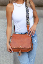 Front view on model wearing jeans and white tank, tan bag with leopard strap-AVAH