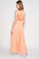 Back view of midi dress in peach satin with subtle elastic waistband and open back detail